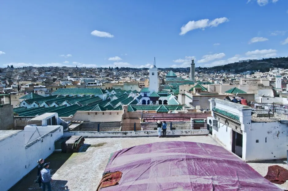 Panoramic view over the rooftops and minarets of Fes el-Bali medina at golden hour